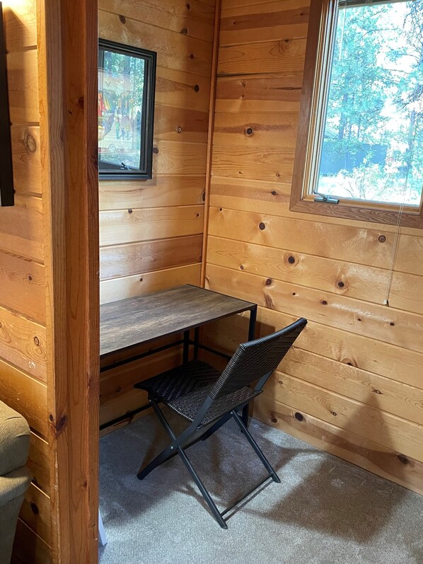 A wooden cabin interior with a desk and chair, a window, and a door. - Sunriver Chalet, Recent Remodel, Top Reviews, Near Deschutes, Dog OK (Sunriver)