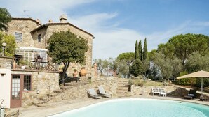 A stone building with a swimming pool, lounge chairs, and a pergola. - Villa Peramonda (Toscana)