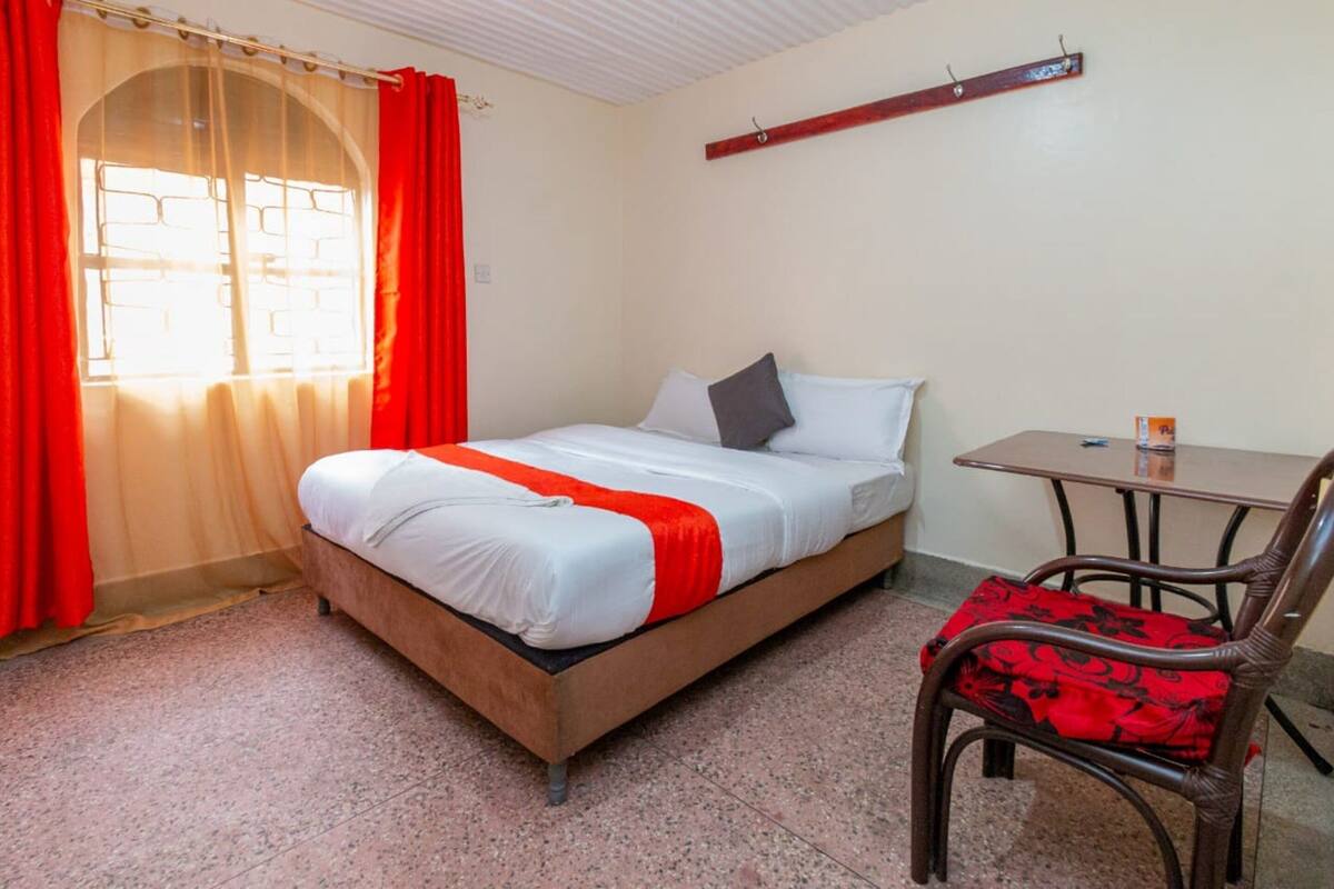 A room with a bed, a table, and a chair.