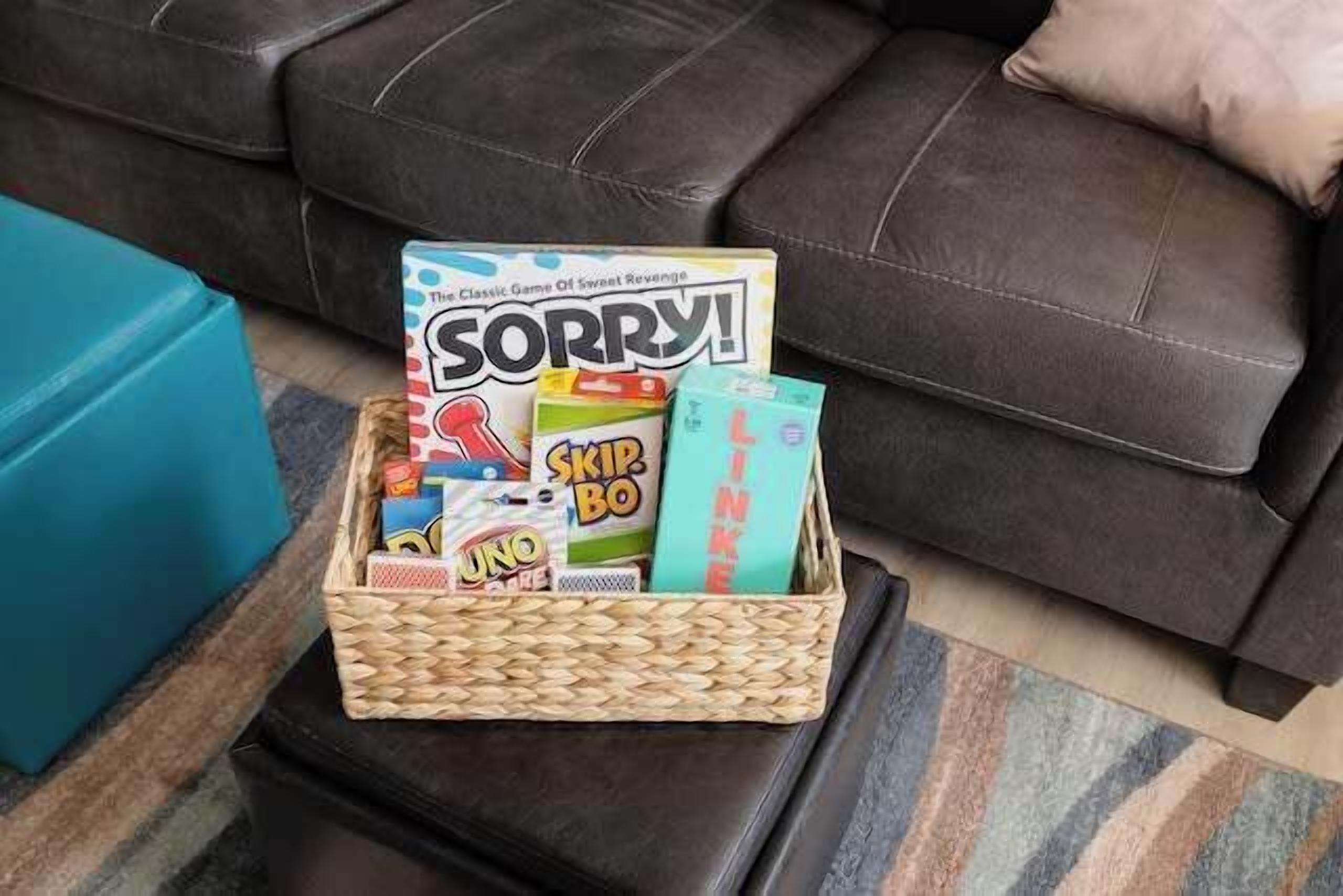 A basket of board games on a small table in a living room.
