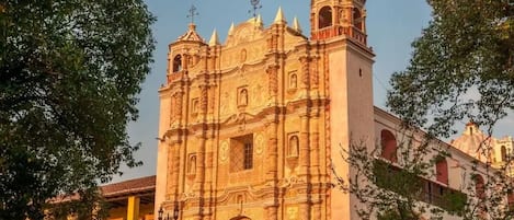 Un edificio histórico con una imponente torre de campanas y una fachada detallada.