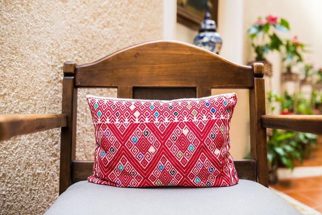 Una silla de madera con un cojín estampado.