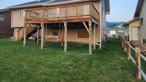 A two-story house with a wooden deck and a covered porch. - South Dakota Black Hills rental (Whitewood,)