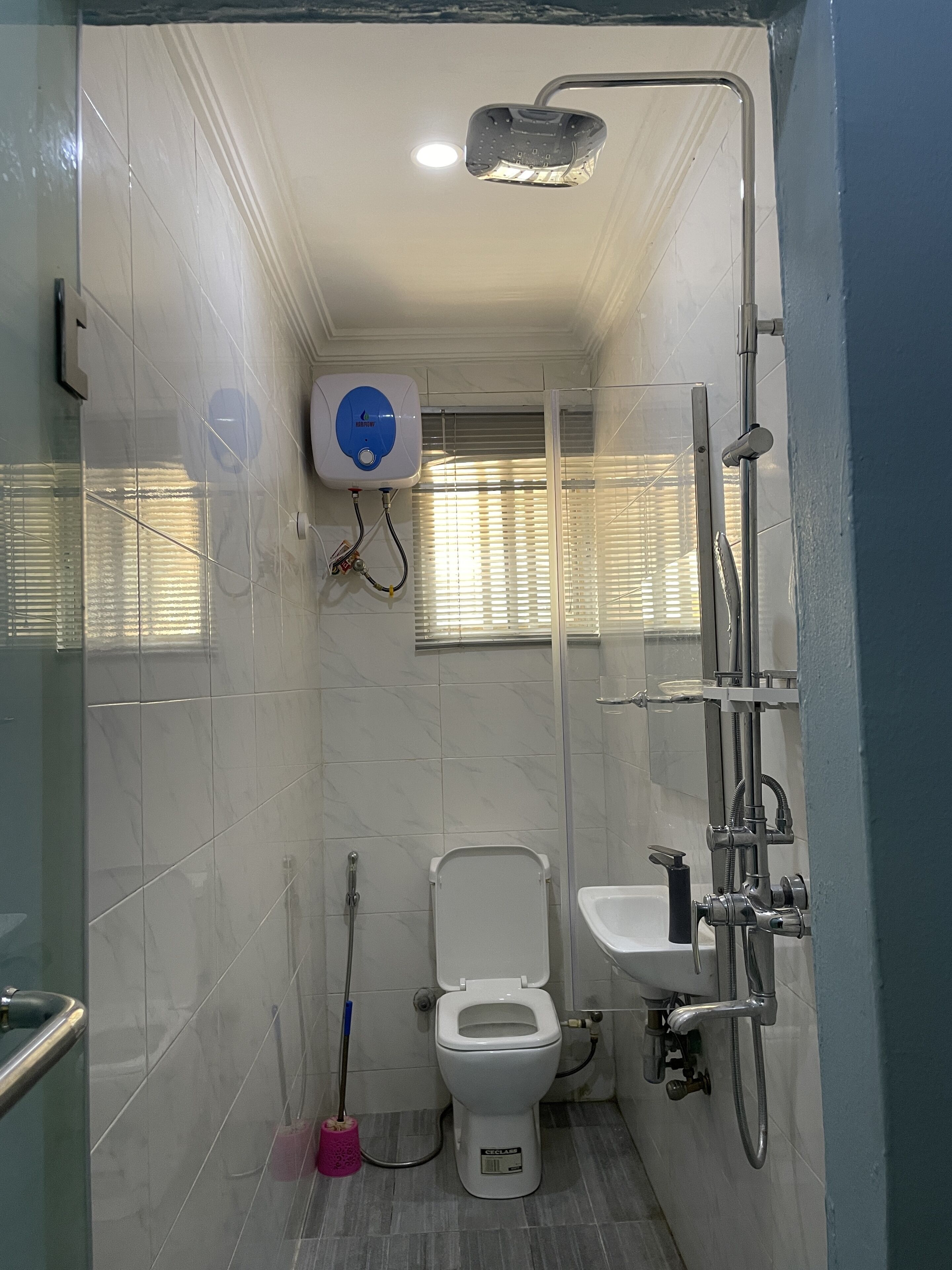 Een kleine badkamer met toilet, wastafel en douche.