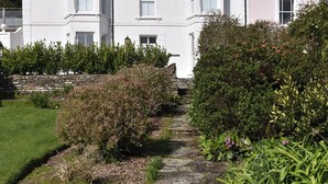 A white building with multiple windows and a stone pathway leading to it. - 3 bedroom accommodation in St Mawes (St Mawes)