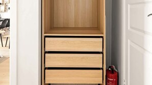 Un dressing avec des tiroirs en bois et une tringle pour suspendre les vêtements.