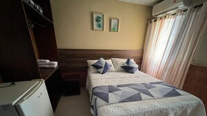 A hotel room with a bed, a wardrobe, and a refrigerator. - POUSADA SAO JOSE (Chapada dos Guimarães)