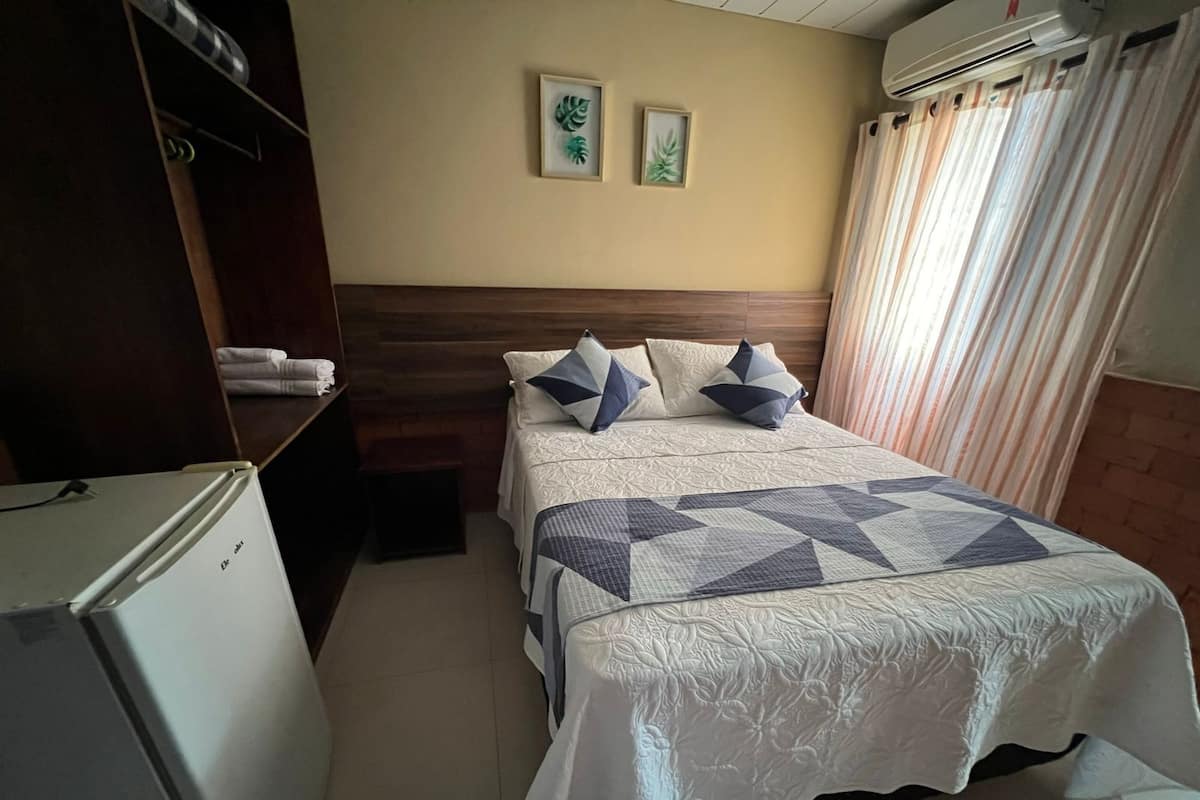 Une chambre d’hôtel avec un lit, une armoire et un réfrigérateur.