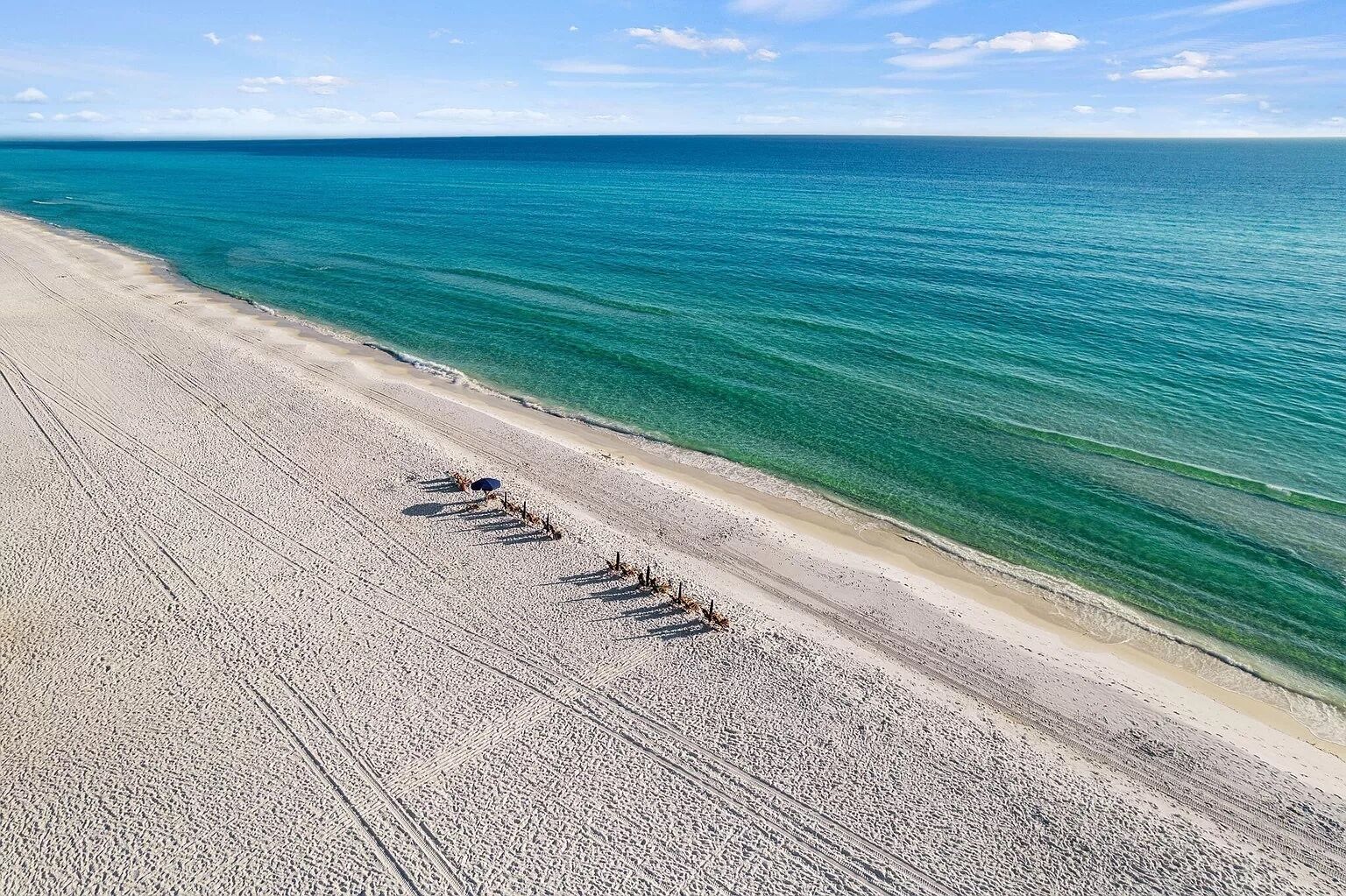 A beach with clear turquoise water and a sandy shore.