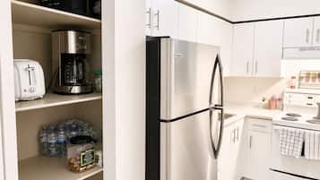 Una cocina moderna con un refrigerador de acero inoxidable, una cafetera y un tostador sobre la encimera.