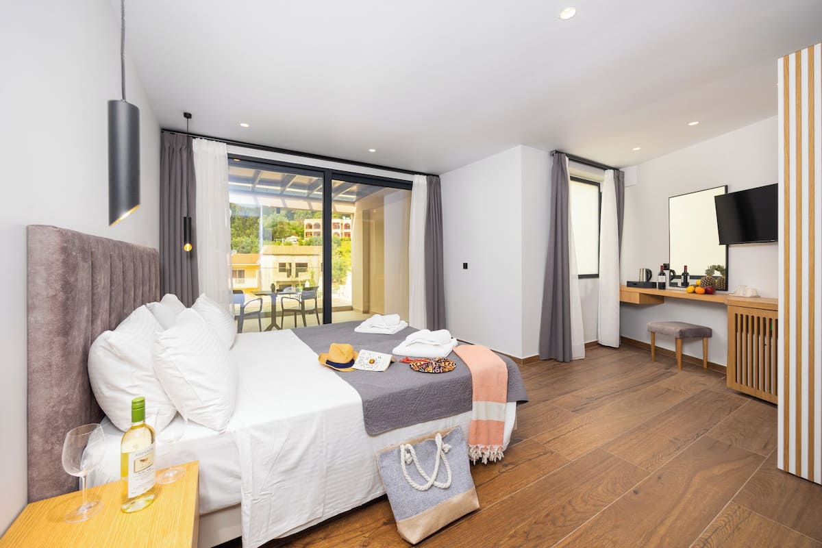 A modern hotel room with a bed, bedside table, and a desk with a chair.