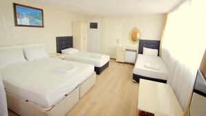Een hotelkamer met twee bedden, een bureau, een kledingkast en een badkamer.