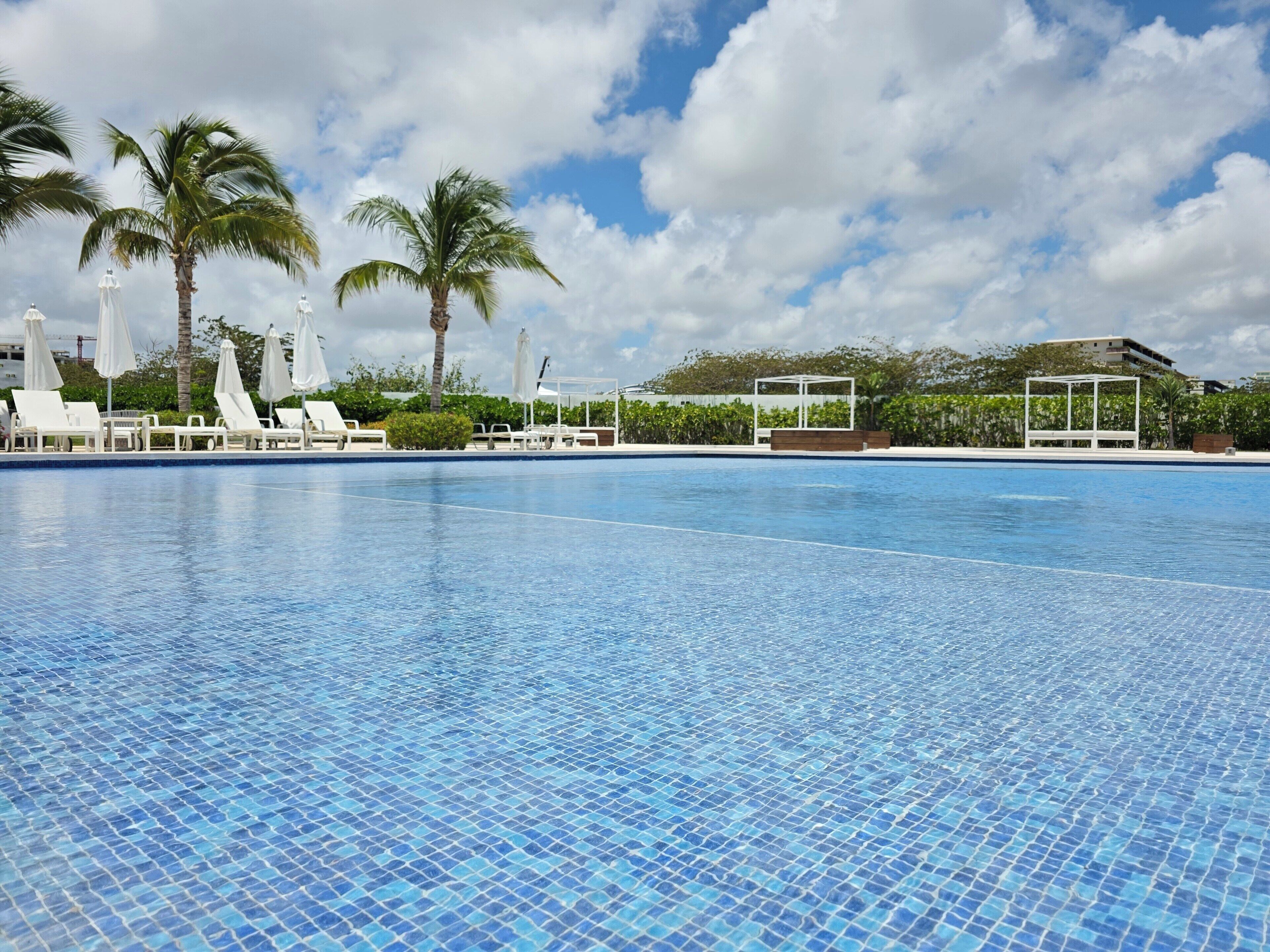 Alberca al aire libre, sombrillas en la alberca y camastros 