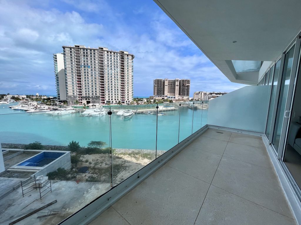 Un balcon donnant sur une plage et un grand bâtiment d’hôtel.