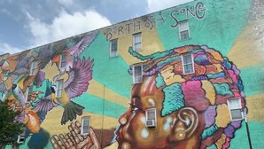 Un mural con el texto 'Birth of a Song' en un edificio.