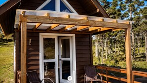 A wooden cabin with a covered porch, a satellite dish, and a view of pine trees. - Recanto das Águas - Urubici - SC (Urubici)