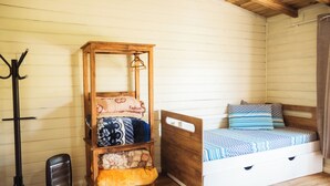 A cozy room with a wooden bed, a small wooden cabinet with a mirror, and a black heater. - Recanto das Águas - Urubici - SC (Urubici)