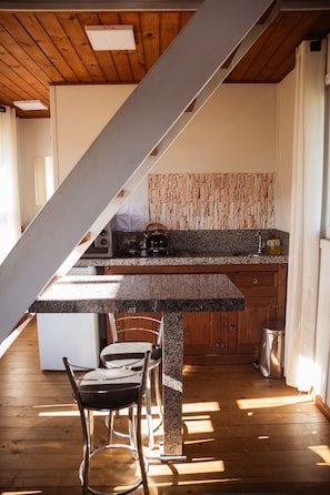 Cabaña | Cocina privada | Frigorífico pequeño, mesa de comedor y isla de cocina
