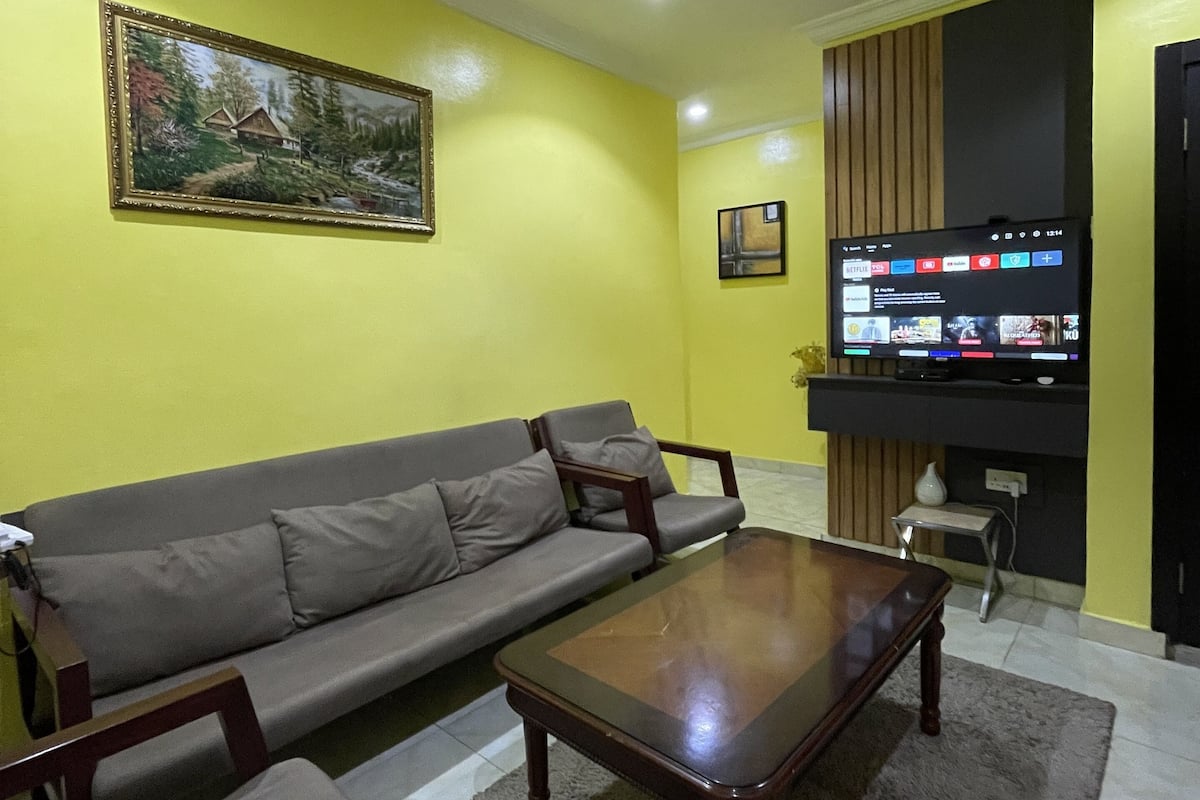 Un salon avec un canapé, une table basse et un téléviseur.