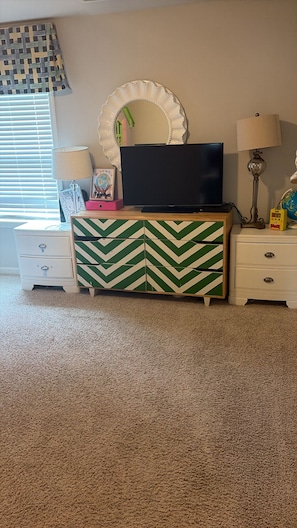A bedroom with a TV on a dresser, a mirror, two bedside tables, and a carpeted floor. - Minutes to Six Flags, Walmart, and the #1 restaurant in town with gated fence!! (Douglasville)