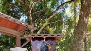 Een houten pergola met een hangend bord met een familiewapen.