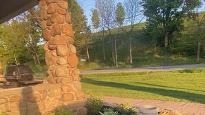 Un jardin aménagé avec différentes espèces de plantes et un pilier en pierre.