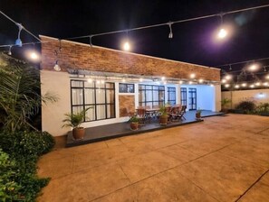 Enjoy dining and socializing in the covered outdoor area with tables and chairs.