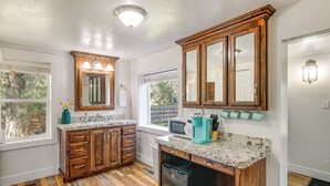 A kitchen with wooden cabinets, a built-in microwave, and a dishwasher. - Rexburg Escape w/ Fenced Yard + Covered Patio! (Rexburg)