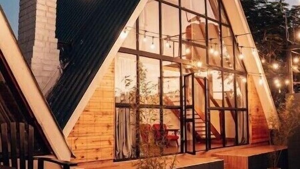 Un bâtiment moderne, de forme triangulaire, doté de grandes fenêtres et d’une façade en bois.