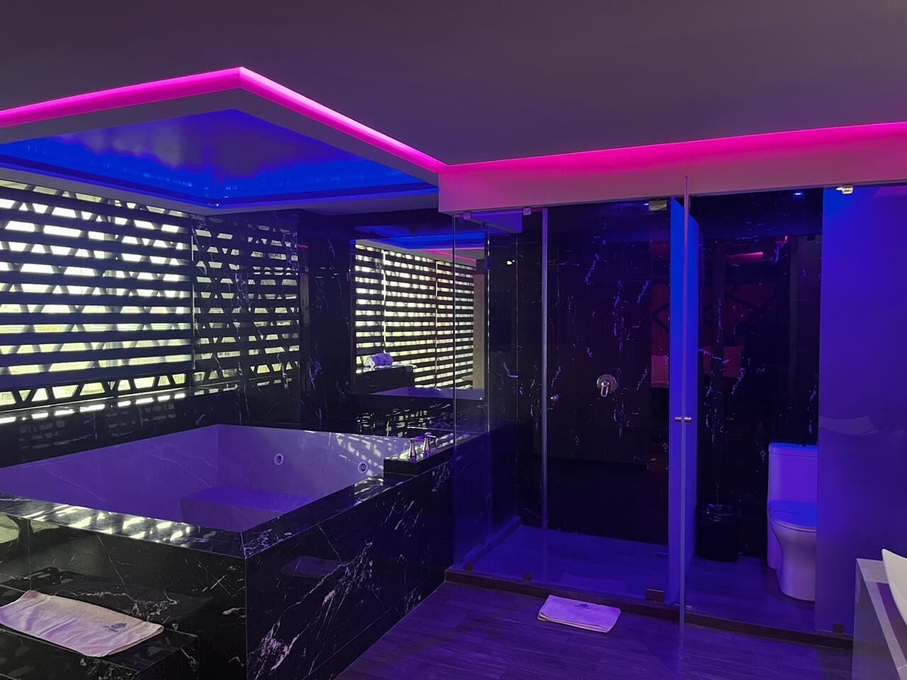 Ein modernes Badezimmer mit einer großzügigen Badewanne, einer Duschkabine aus Glas und einem Waschtisch mit Spiegel.