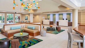 A modern hotel lobby with a reception desk, seating areas, and a decorative ceiling light fixture. - 25% off Westin St. John Bay Vista 3BR Sleeps 10 3BD/3BA - 7/4/2026 to 7/11/2026 (Cruz Bay)