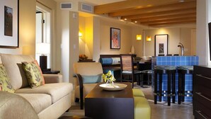 A modern living room with a sofa, a coffee table, and a dining area with a bar. - 25% off Westin St. John Bay Vista 3BR Sleeps 10 3BD/3BA - 7/4/2026 to 7/11/2026 (Cruz Bay)