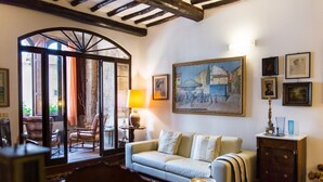 A cozy living room with a sofa, a coffee table, and a painting on the wall.