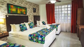 Una habitación de hotel con una cama grande, una cama más pequeña, un escritorio y un armario.
