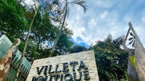 A sign for Villeta Boutique Hotel-Spa with a stone facade and decorative elements.