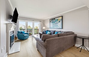 Un salon moderne avec un canapé gris, un fauteuil bleu et une petite table.