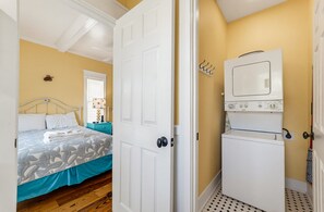 A bedroom with a bed, a nightstand, and a wall-mounted lamp.