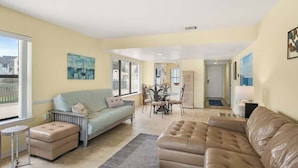 A living room with a sofa, ottoman, dining table, chairs, and artwork on the walls. - 622 Newhaven (Fripp Island)
