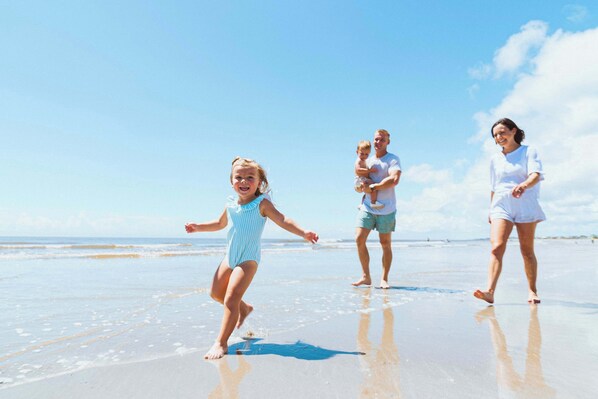 En strandscen med en familj som promenerar på sanden.