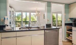 A modern kitchen with a large island, a dishwasher, and a view of the outdoors. - 657 Newhaven (Saint Helena Island)