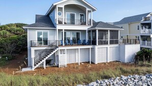 Une maison à deux étages dotée d’un balcon, d’un porche couvert et d’un escalier menant à l’étage supérieur.