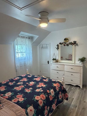 A bedroom with a bed, a dresser, a ceiling fan, a window with curtains, and a door. - Sweet Escape on Reese Avenue - 5 minutes away from Hershey Park! (Hershey)