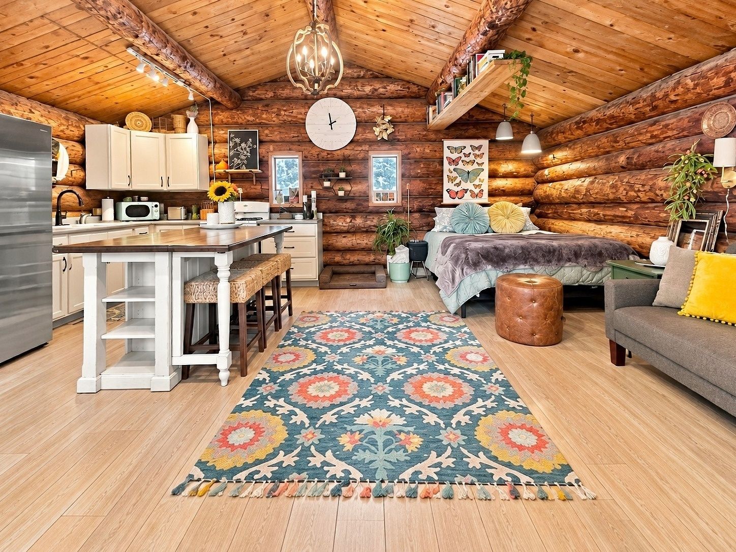 L’intérieur d’une cabane en rondins comprend une cuisine, un coin repas et une chambre confortable avec un lit et un espace salon.