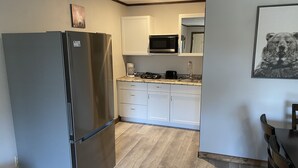 A compact kitchen with a refrigerator, microwave, and white cabinets. - 2BD 2BA w/Kitchenette close to Silver Dollar City (Branson)