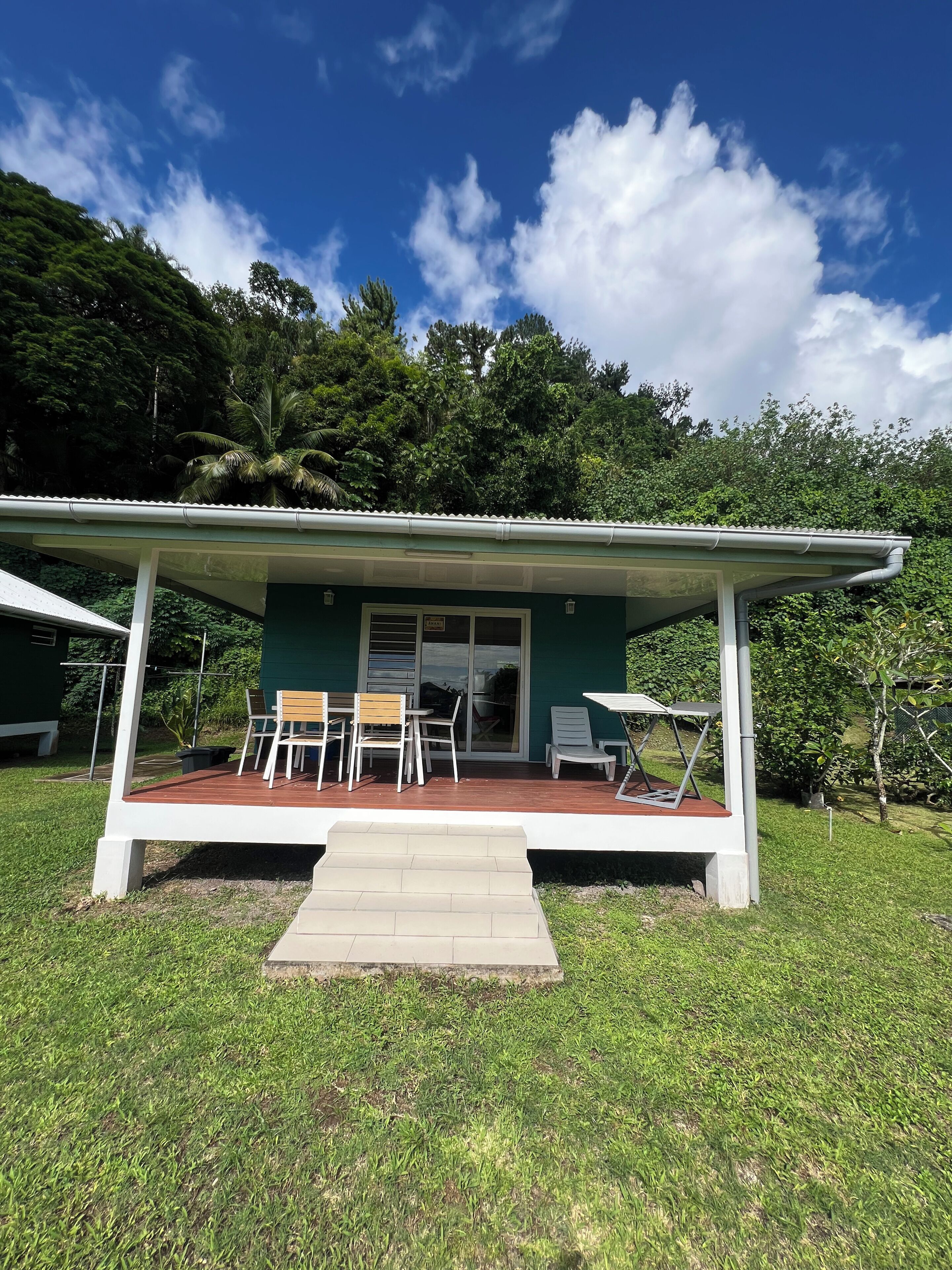 A house with a covered patio, a sliding glass door, and a small outdoor seating area with chairs and a table.
