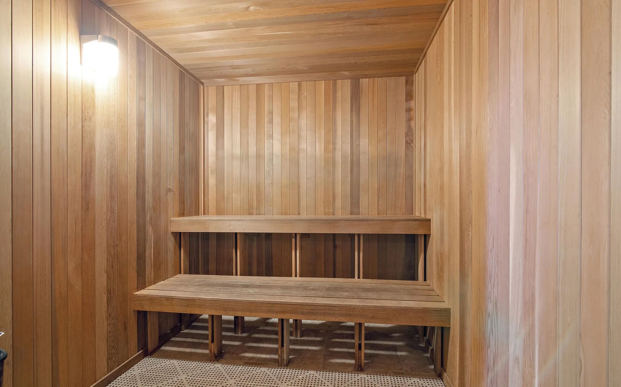 A sauna with wooden walls and a bench.
