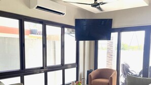Ein modernes Wohnzimmer mit zwei Sofas, einem Couchtisch und einem an der Wand befestigten Fernseher.