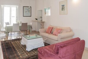 A living room with a beige sofa, a glass coffee table, and a patterned rug. - Santa Domenica Guest House II (Catania)