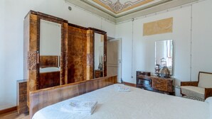 A spacious bedroom with a large bed, wooden wardrobe, and a vanity with a mirror. - Villa Anna in Monferrato (Rosignano Monferrato)