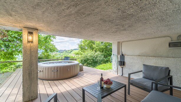 A covered outdoor area with a hot tub, seating, and a view of greenery. - Villa Anna in Monferrato (Rosignano Monferrato)